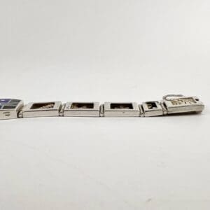 Silver charm bracelet with rectangular links.