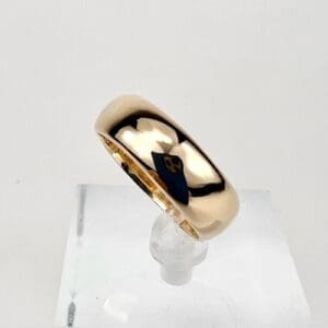Gold ring on a clear display stand.