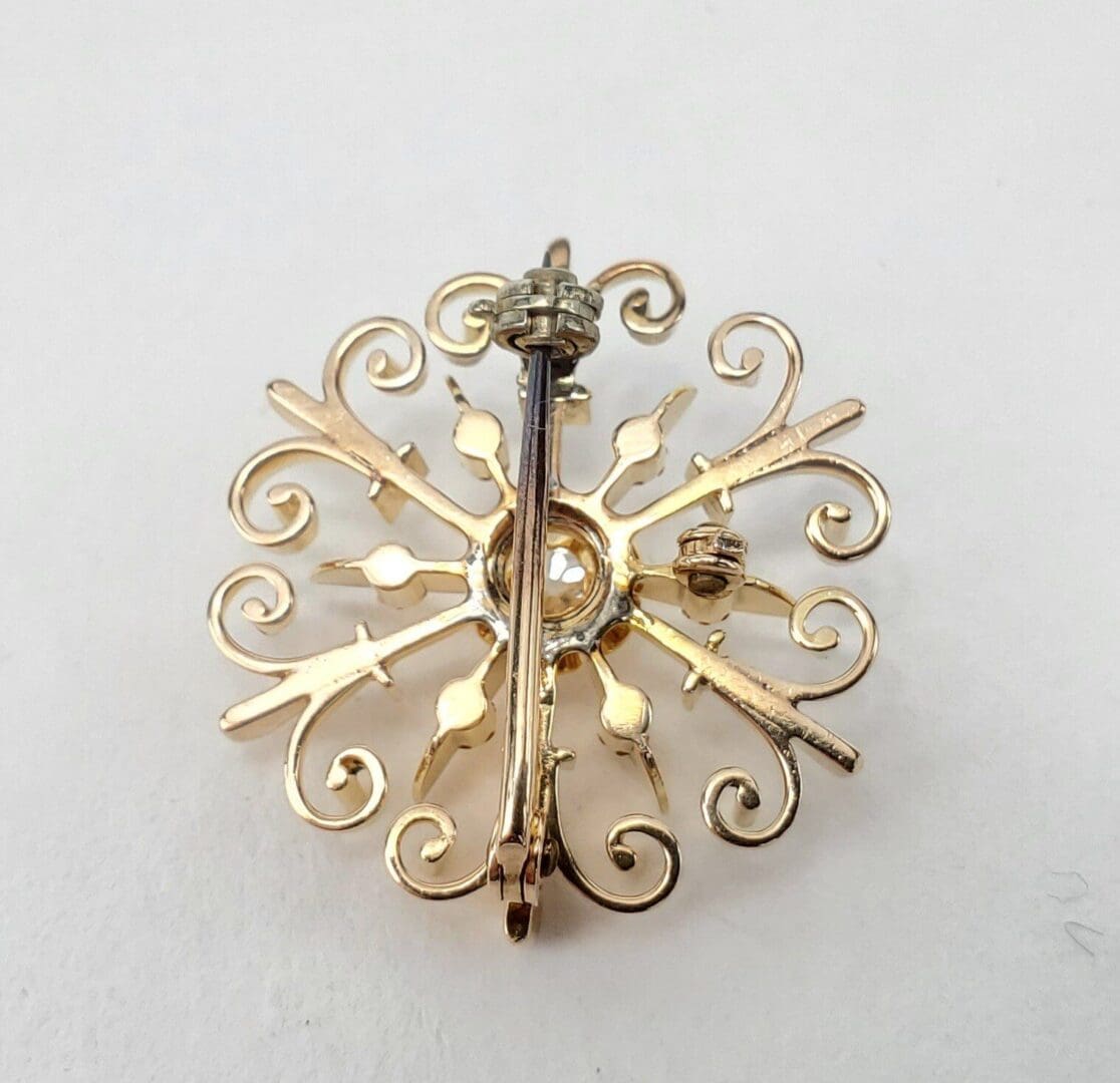 Gold ornate brooch with intricate design.