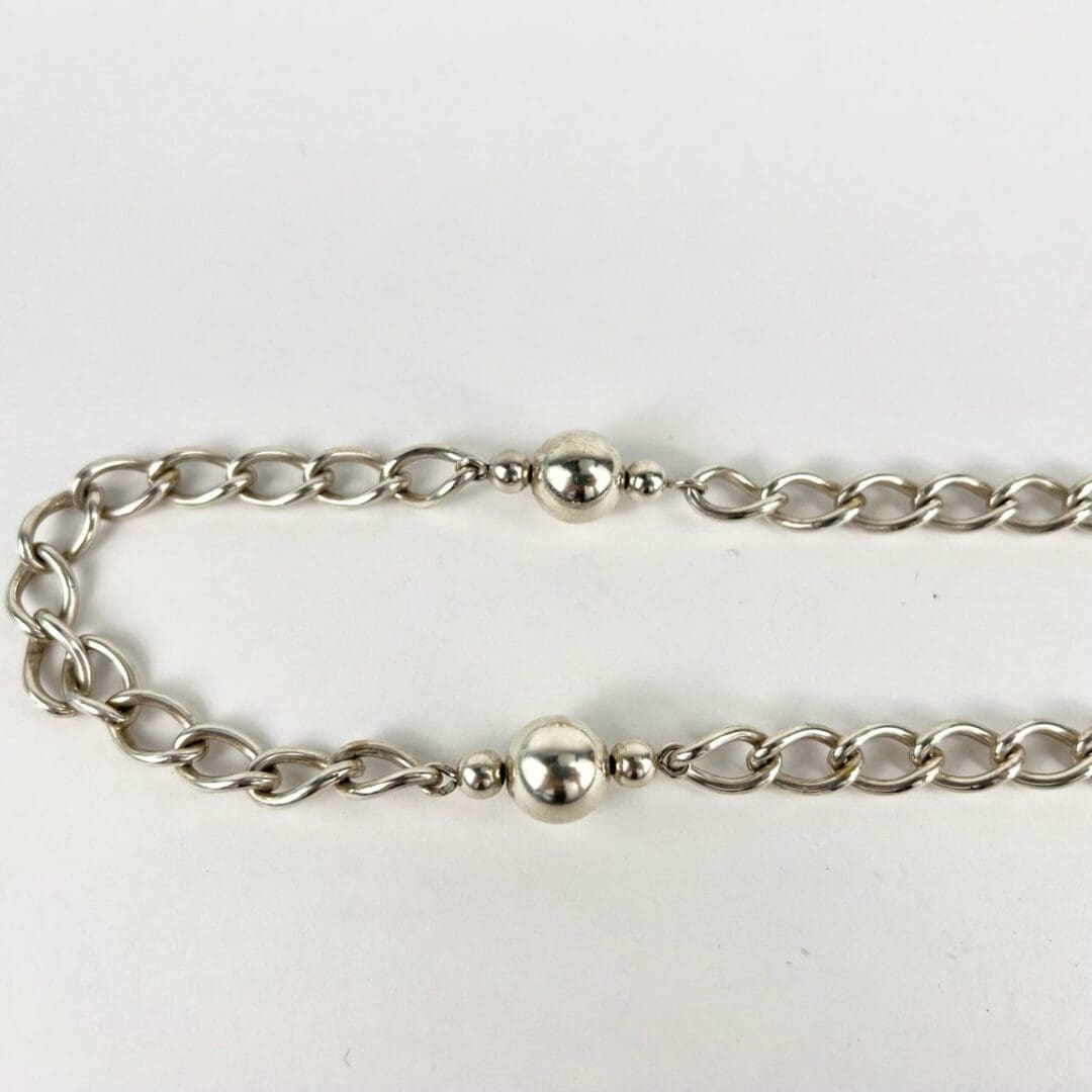 Silver chain bracelet with round beads.