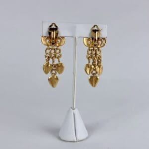 Gold dangling earrings with heart charms.