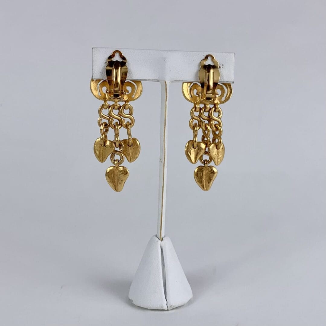 Gold dangling earrings with heart charms.