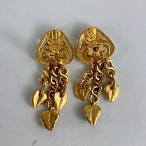 Gold earrings with heart-shaped pendants.