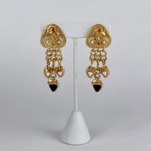 Gold chandelier earrings with black accents.