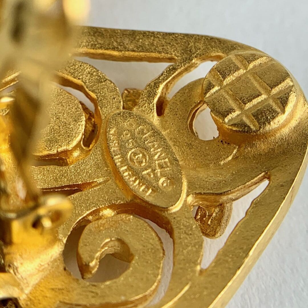 Gold-colored, intricate, engraved pattern with text.