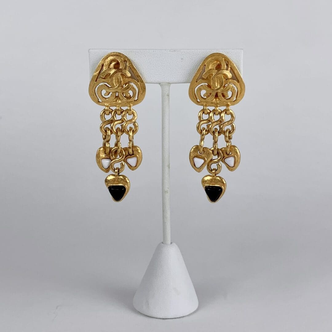 Gold chandelier earrings with black accents.