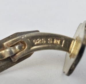 Close-up of silver jewelry with "925" mark.