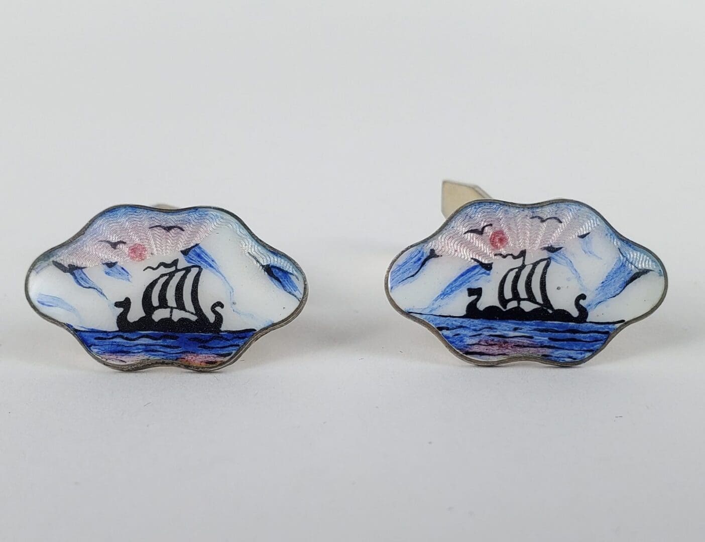 Viking ship cufflinks with enamel design.