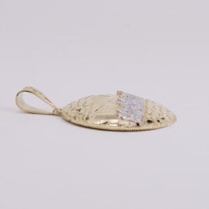 Gold pendant with intricate textured design.