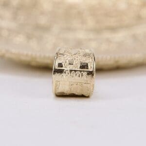 Gold bead with engraved "G10K" marking.