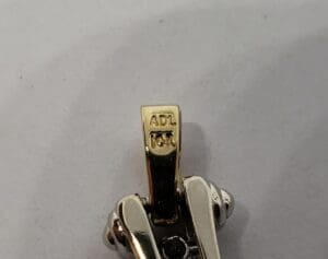 Gold pendant clasp with engraved markings.