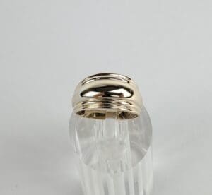 Gold ring on clear display stand.