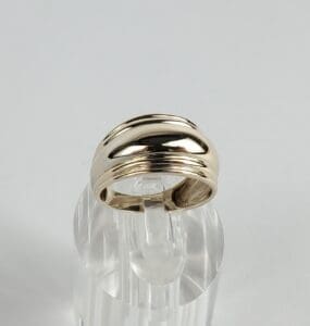 Gold ring on clear display stand.