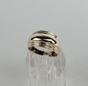 Gold ring on clear display stand.