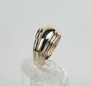 Gold ring on a clear display stand.