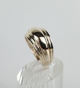 Gold ring on clear display stand.