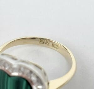 Gold ring with engraved markings inside band.