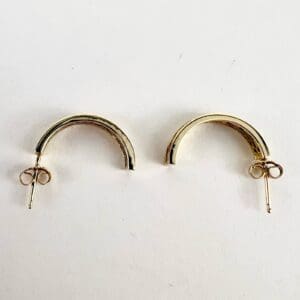 Gold hoop earrings on white background.