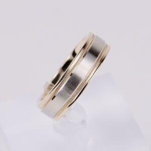 Silver and gold wedding band on display.