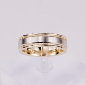 Silver and gold wedding band on display.