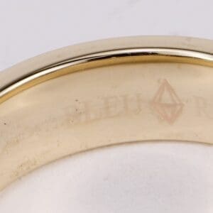 Gold ring with engraved text inside band.