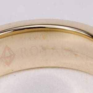 Gold ring with engraved text and symbol.