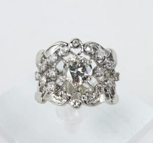 Ornate silver ring with central diamond.