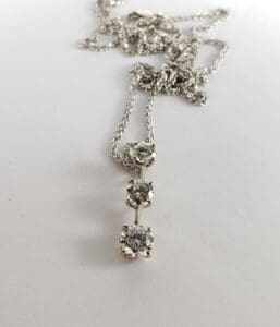 Silver necklace with three diamond pendants.