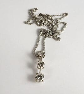 Silver necklace with three diamond pendants.
