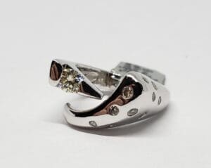 Abstract silver ring with diamond accents.