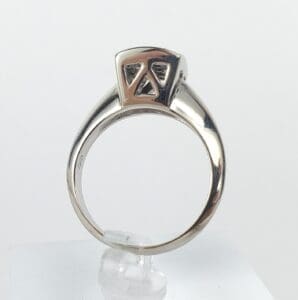 Silver ring with geometric design on top.