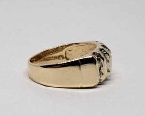 Gold ring with gemstone accents, side view.