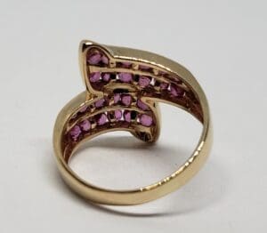 Gold ring with pink gemstones inside.