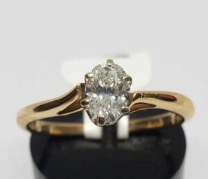 Gold ring with oval diamond solitaire.