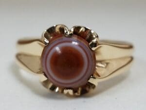 Gold ring with striped circular gemstone.