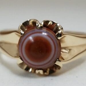 Gold ring with striped circular gemstone.