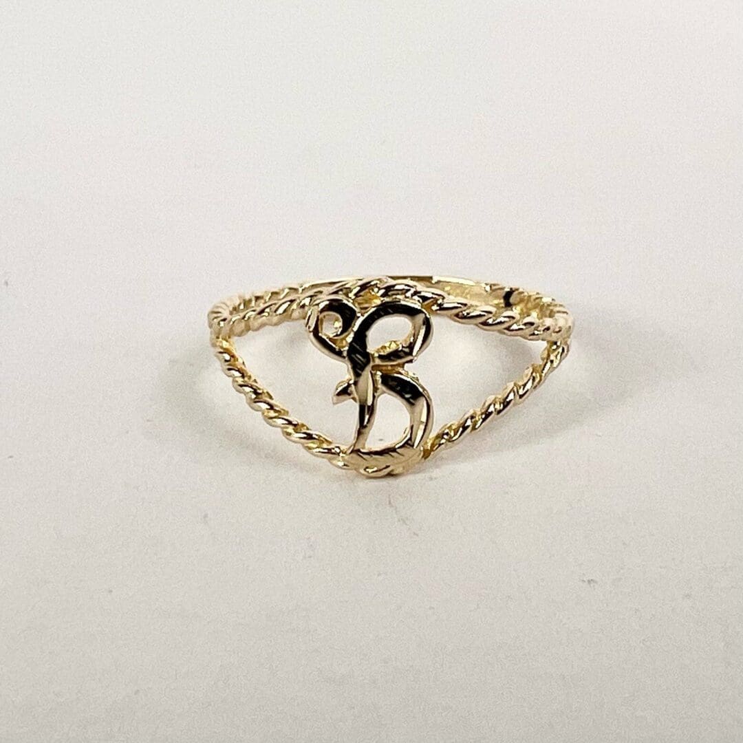 Gold ring with ornate letter "B".