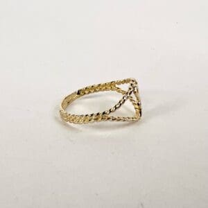 Gold twisted rope design ring on display.