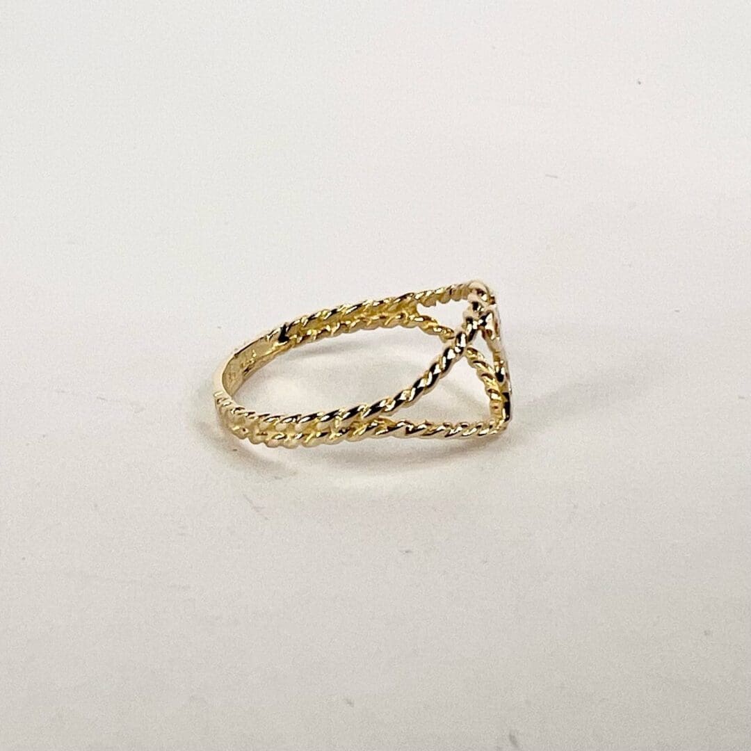 Gold twisted rope design ring on display.