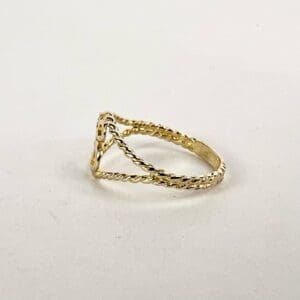 Gold twisted band ring on white background.