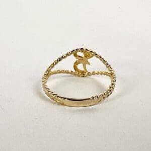 Gold ring with letter "R" design.