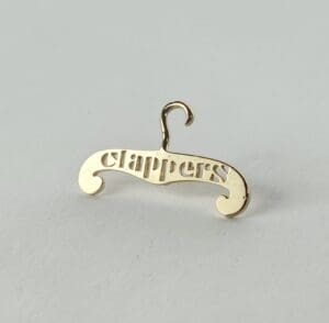 Gold hanger pin with "clappers" inscription.