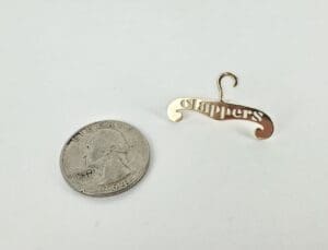 Miniature hanger with "Clippers" beside quarter coin.