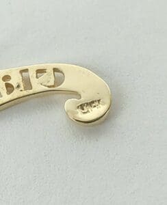Gold jewelry piece with engraved details.