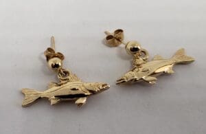 Gold fish-shaped earrings on white background.