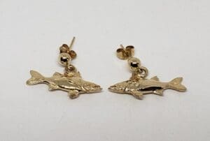 Gold fish-shaped earrings on white background.