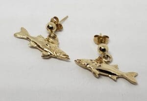 Gold fish-shaped earrings on display.