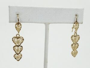 Gold heart-shaped dangle earrings on display.
