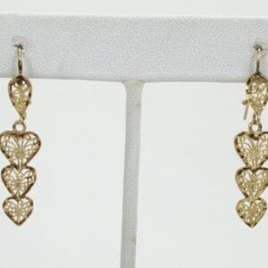 Gold heart-shaped dangle earrings on display.