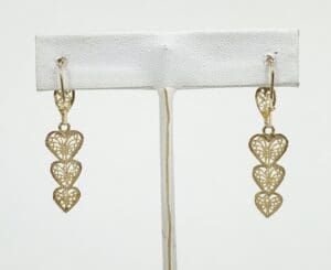 Gold heart-shaped dangle earrings on display.